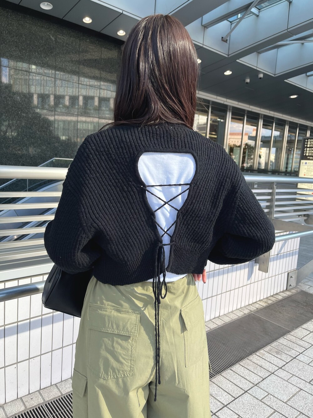 ブラック系のワンピース、グリーン系のカーゴパンツ、ブラック系のハンドバッグを着用したレディースの冬コーディネートの5枚目の写真
