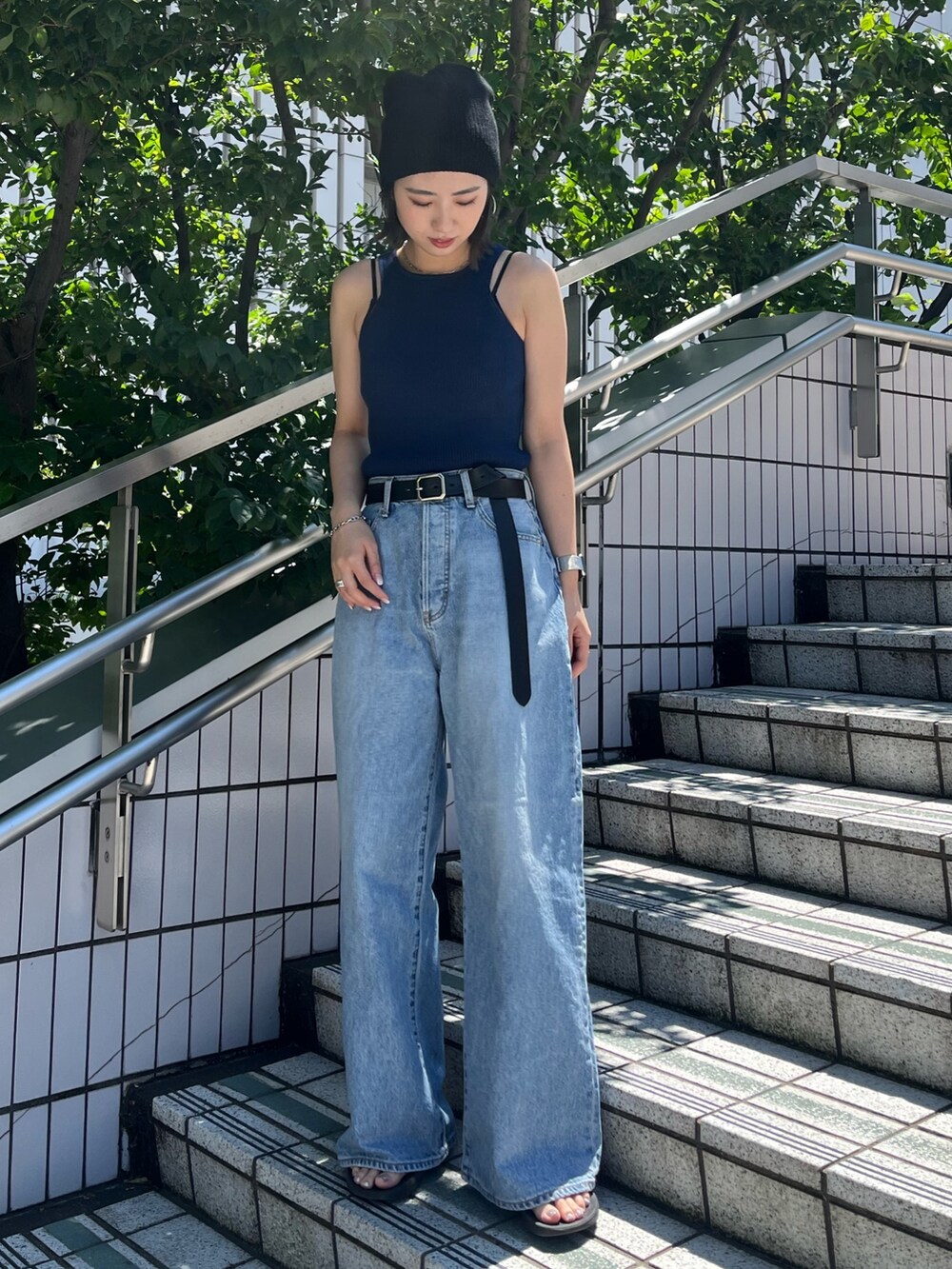 ブルー系のタンクトップ、ブルー系のデニムパンツ、ブラック系のベルトを着用したレディースの夏コーディネートの2枚目の写真