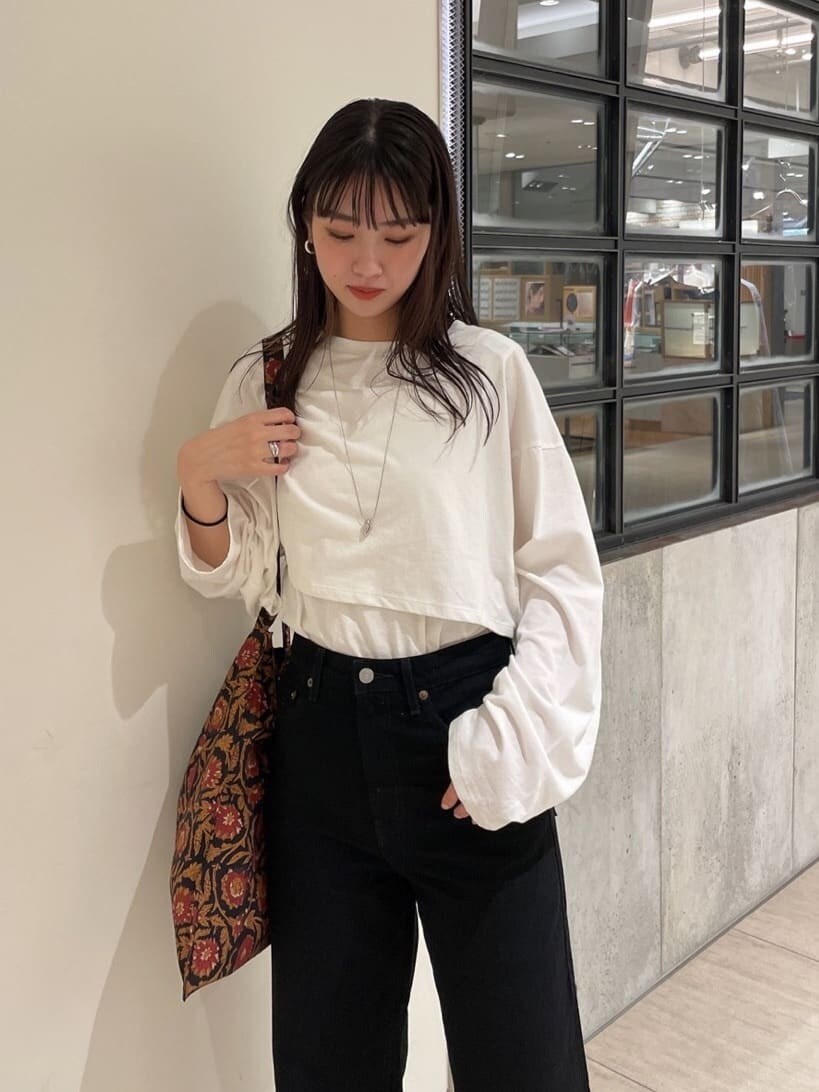 ホワイト系のTシャツ/カットソー、ブラック系のデニムパンツ、ブラック系のパンプスを着用したレディースの秋コーディネートの2枚目の写真