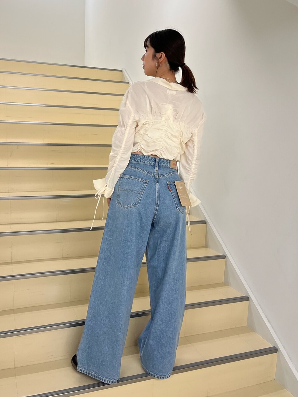 ホワイト系のシャツ/ブラウス、ブルー系のデニムパンツを着用したレディースの秋コーディネートの4枚目の写真