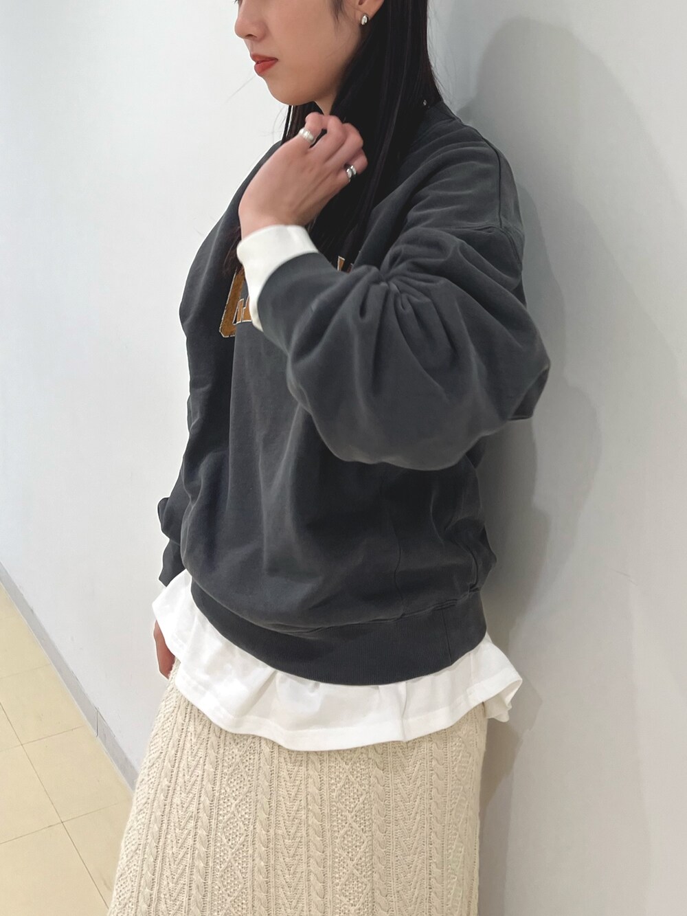 グレー系のTシャツ/カットソー、ホワイト系のTシャツ/カットソー、ホワイト系のスカートを着用したレディースの冬コーディネートの3枚目の写真