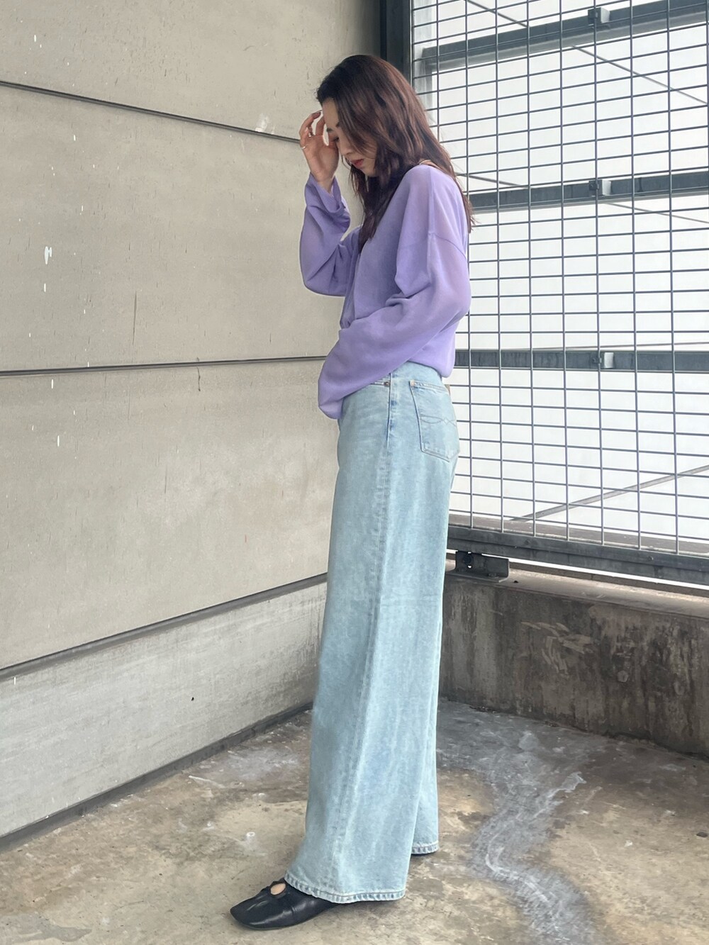 パープル系のニット/セーター、ブルー系のデニムパンツを着用したレディースの春コーディネートの3枚目の写真
