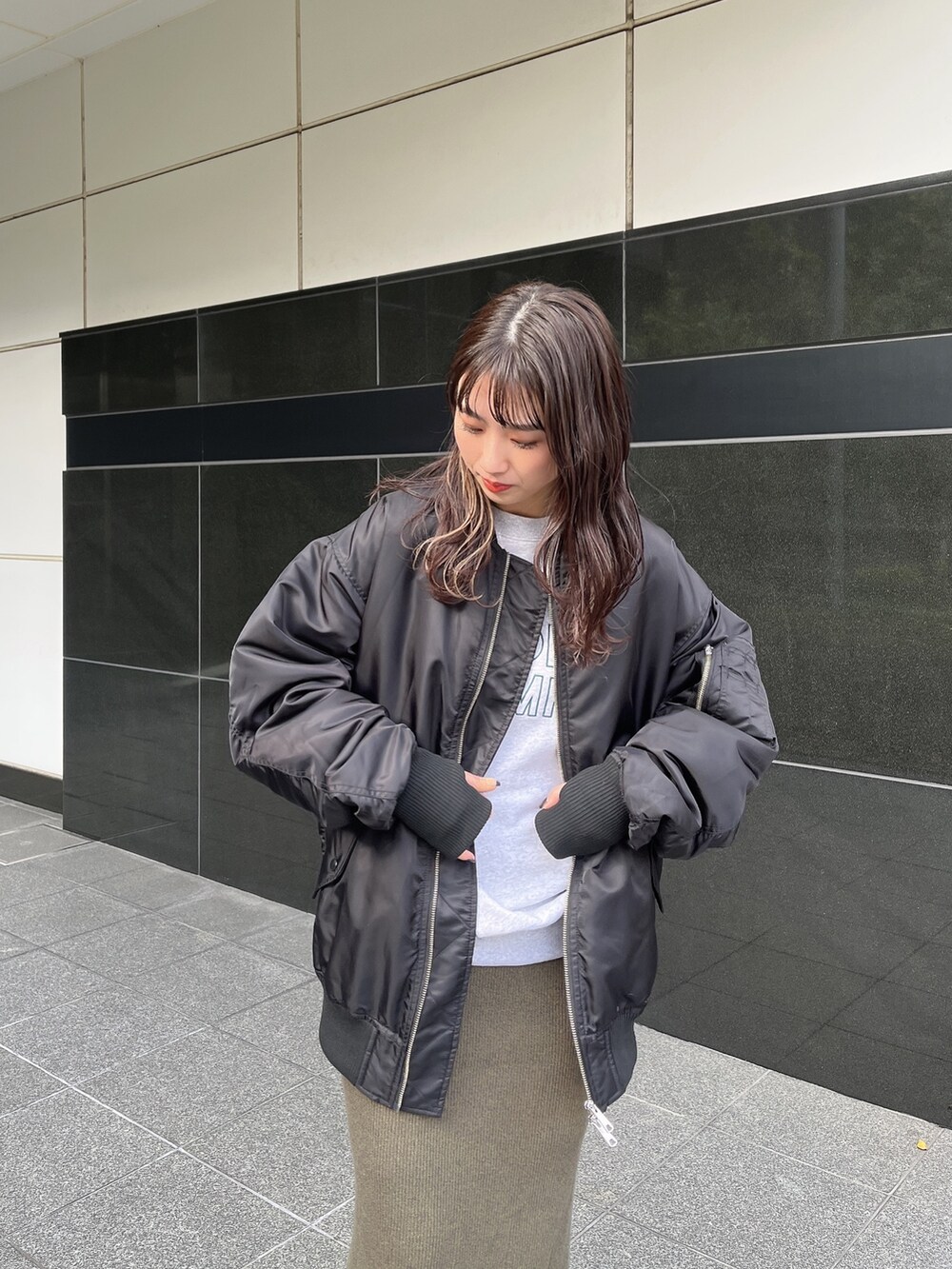 ブラック系のMA-1、グレー系のスウェット、グリーン系のスカートを着用したレディースの秋コーディネートの5枚目の写真