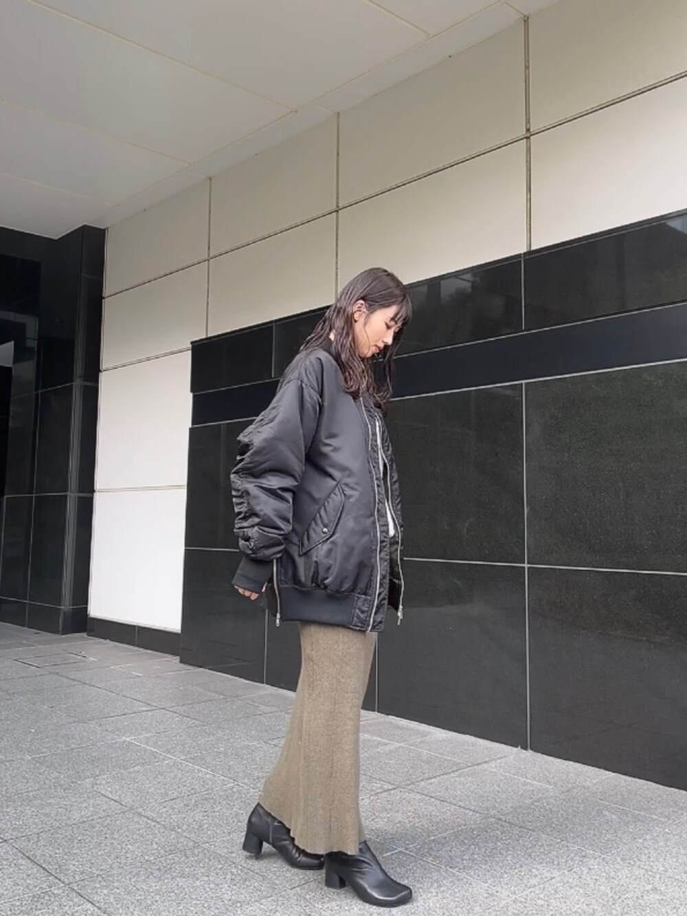 ブラック系のMA-1、グレー系のスウェット、グリーン系のスカートを着用したレディースの秋コーディネートの3枚目の写真