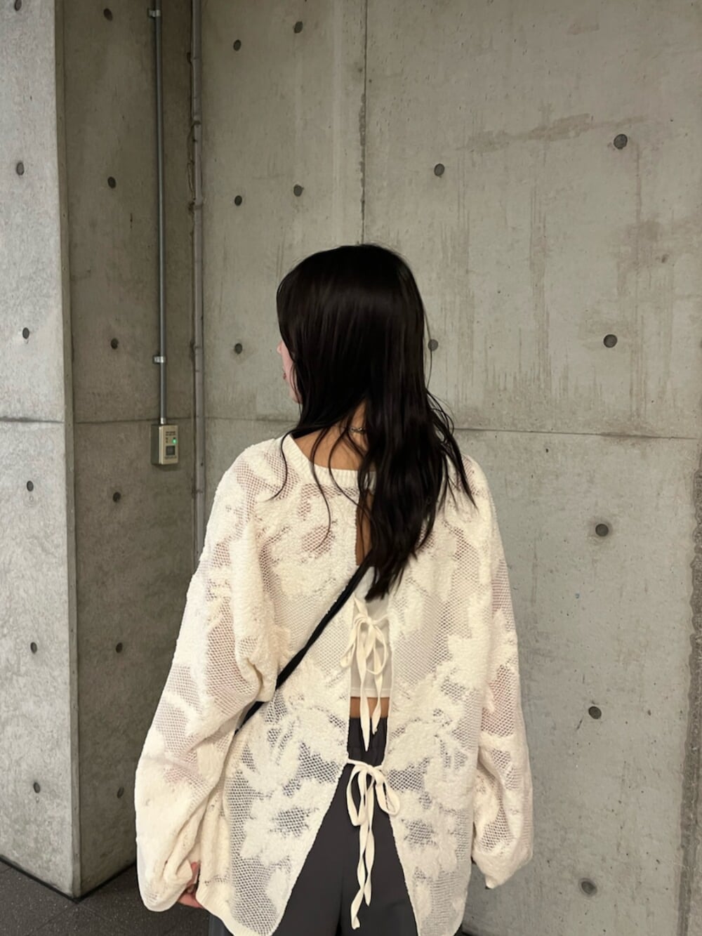 ホワイト系のニット/セーター、グレー系のその他パンツ、ブラック系のショルダーバッグを着用したレディースの秋コーディネートの4枚目の写真