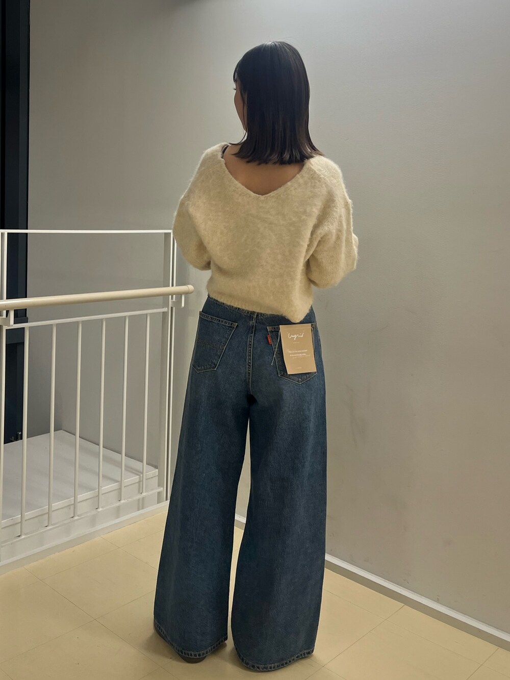 ホワイト系のニット/セーター、ブルー系のデニムパンツを着用したレディースの秋コーディネートの3枚目の写真