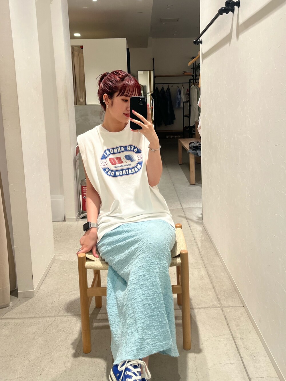 ホワイト系のタンクトップ、ブルー系のスカート、ブルー系のスニーカーを着用したレディースの夏コーディネートの4枚目の写真