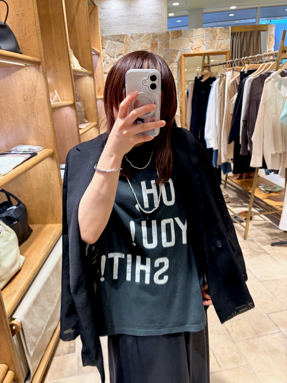 ブラック系のTシャツ/カットソー、ブラック系のテーラードジャケット、ブルー系のスカートを着用したレディースの春コーディネートの2枚目の写真
