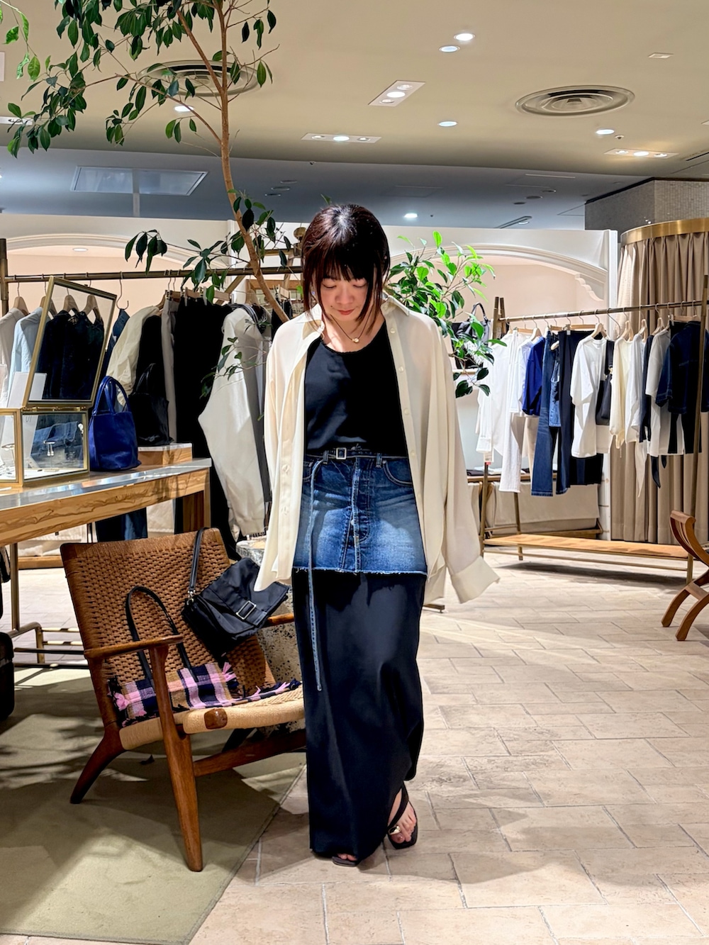 ホワイト系のシャツ/ブラウス、ブラック系のスカート、ブラウン系のサンダルを着用したレディースの春コーディネートの2枚目の写真