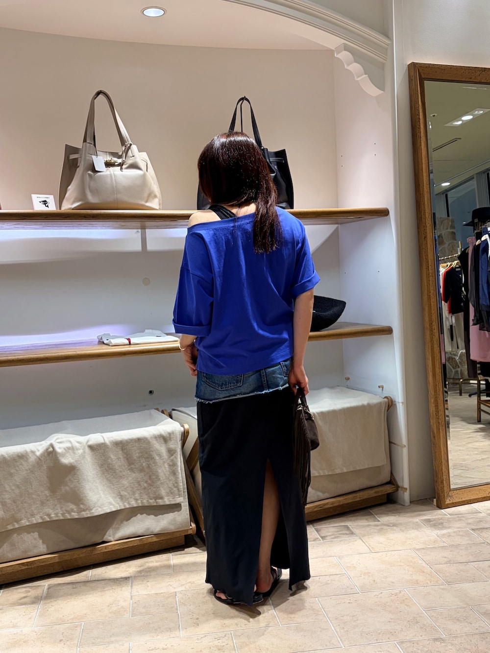 ブルー系のTシャツ/カットソー、ブラック系のその他シューズ、ブルー系のデニムスカートを着用したレディースの夏コーディネートの2枚目の写真