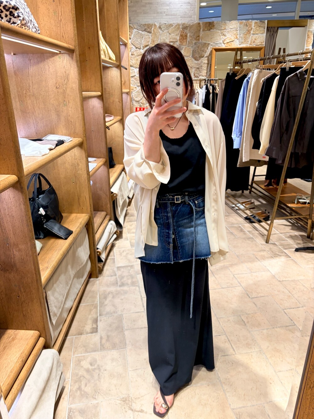 ホワイト系のシャツ/ブラウス、ブラック系のスカート、ブラウン系のサンダルを着用したレディースの春コーディネートの5枚目の写真