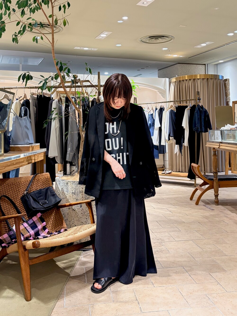 ブラック系のTシャツ/カットソー、ブラック系のテーラードジャケット、ブルー系のスカートを着用したレディースの春コーディネートの3枚目の写真