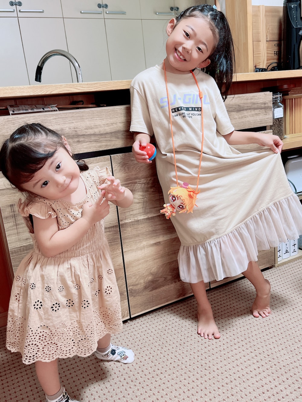 ベージュ系のワンピース、ベージュ系のチュニック、ブラック系のスニーカーを着用したキッズの秋コーディネートの2枚目の写真