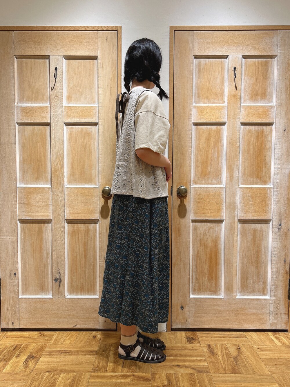 ブラウン系のサンダル、ベージュ系のハンドバッグ、ホワイト系のTシャツ/カットソーを着用したレディースの春コーディネートの2枚目の写真