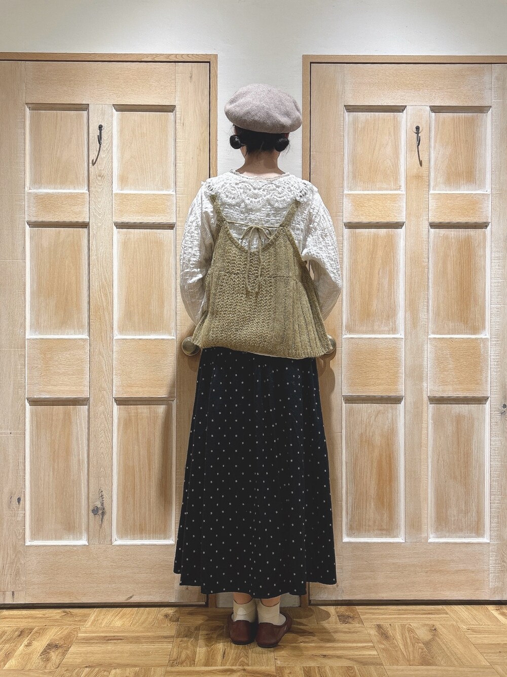 イエロー系のニット/セーター、ホワイト系のシャツ/ブラウス、ブラック系のスカートを着用したレディースの秋コーディネートの3枚目の写真