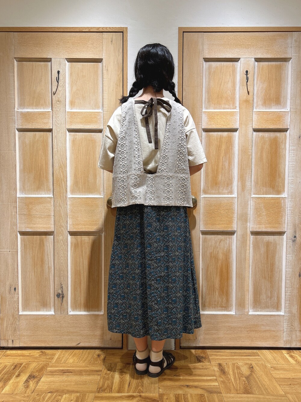 ブラウン系のサンダル、ベージュ系のハンドバッグ、ホワイト系のTシャツ/カットソーを着用したレディースの春コーディネートの3枚目の写真