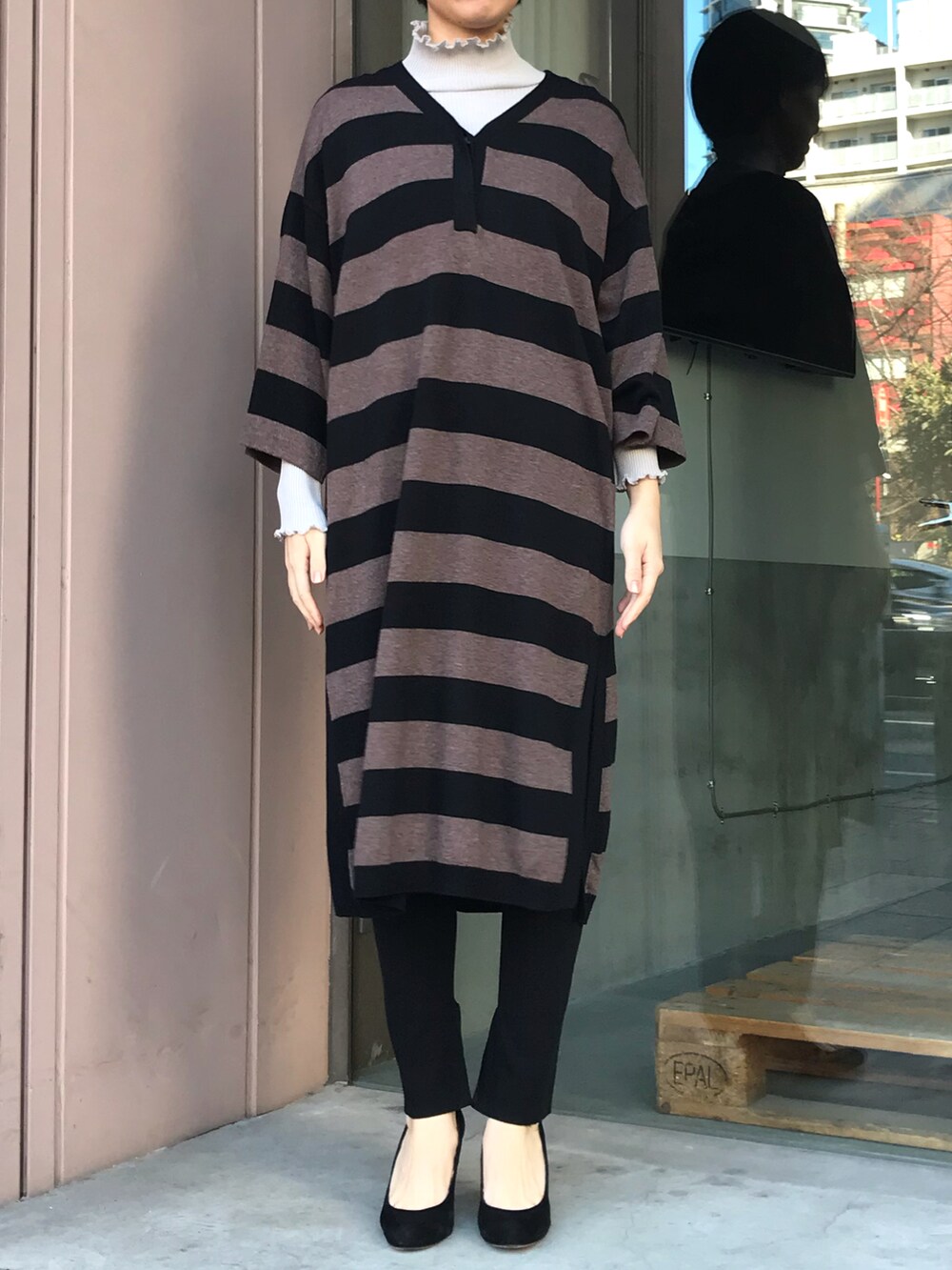 ブラック系のニット/セーター、ベージュ系のTシャツ/カットソー、ブラック系のパンツを着用したレディースの冬コーディネートの3枚目の写真