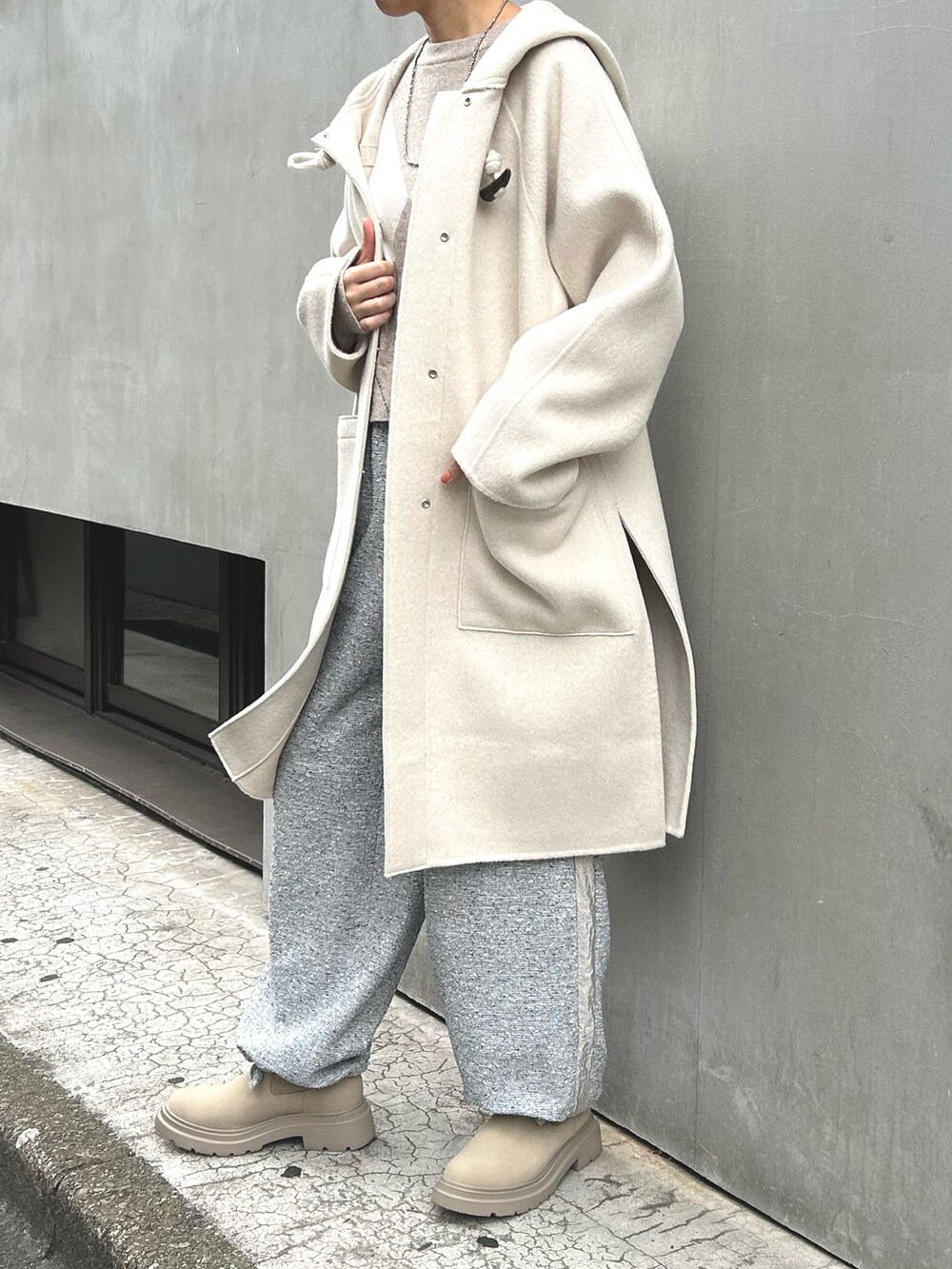 グレー系のその他パンツ、ベージュ系のニット/セーター、ホワイト系のダッフルコートを着用したレディースの冬コーディネートの2枚目の写真