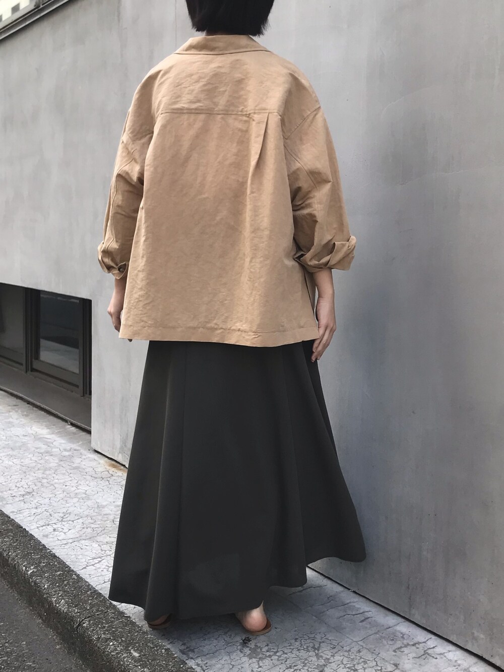 ベージュ系のテーラードジャケット、ホワイト系のシャツ/ブラウス、グリーン系のスカートを着用したレディースの春コーディネートの3枚目の写真