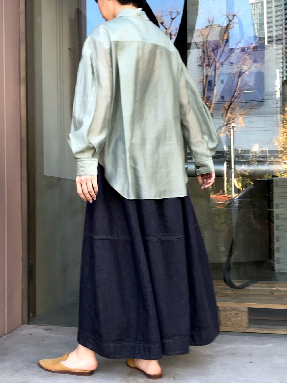 グリーン系のシャツ/ブラウス、ブルー系のデニムスカートを着用したレディースの春コーディネートの2枚目の写真