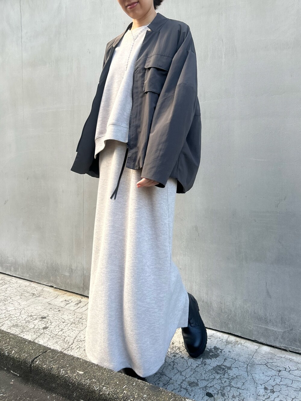 グレー系のブルゾン、ベージュ系のワンピース、ベージュ系のTシャツ/カットソーを着用したレディースの冬コーディネートの2枚目の写真