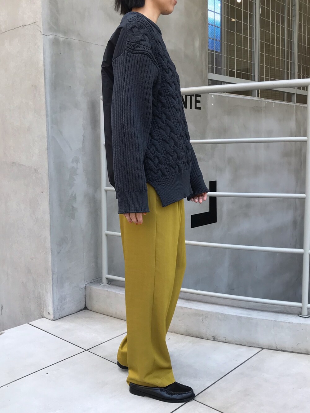イエロー系のその他パンツ、グレー系のニット/セーターを着用したレディースの秋コーディネートの2枚目の写真