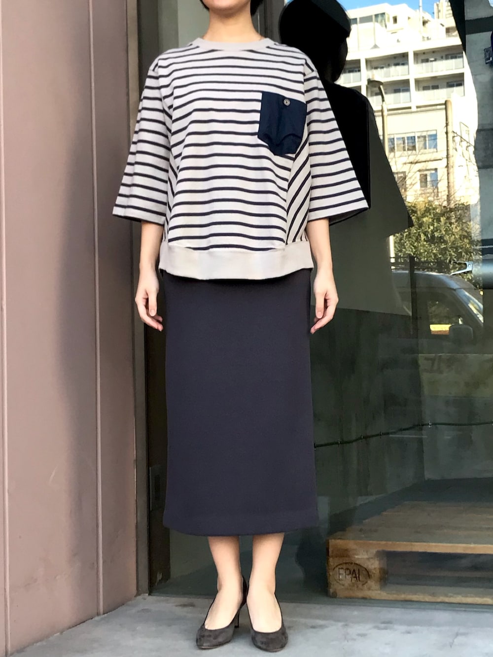 ベージュ系のスウェット、グレー系のスカートを着用したレディースの春コーディネートの2枚目の写真