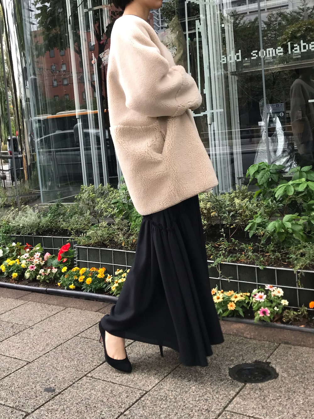 ブラック系のスカート、ベージュ系のムートンコートを着用したレディースの秋コーディネートの4枚目の写真