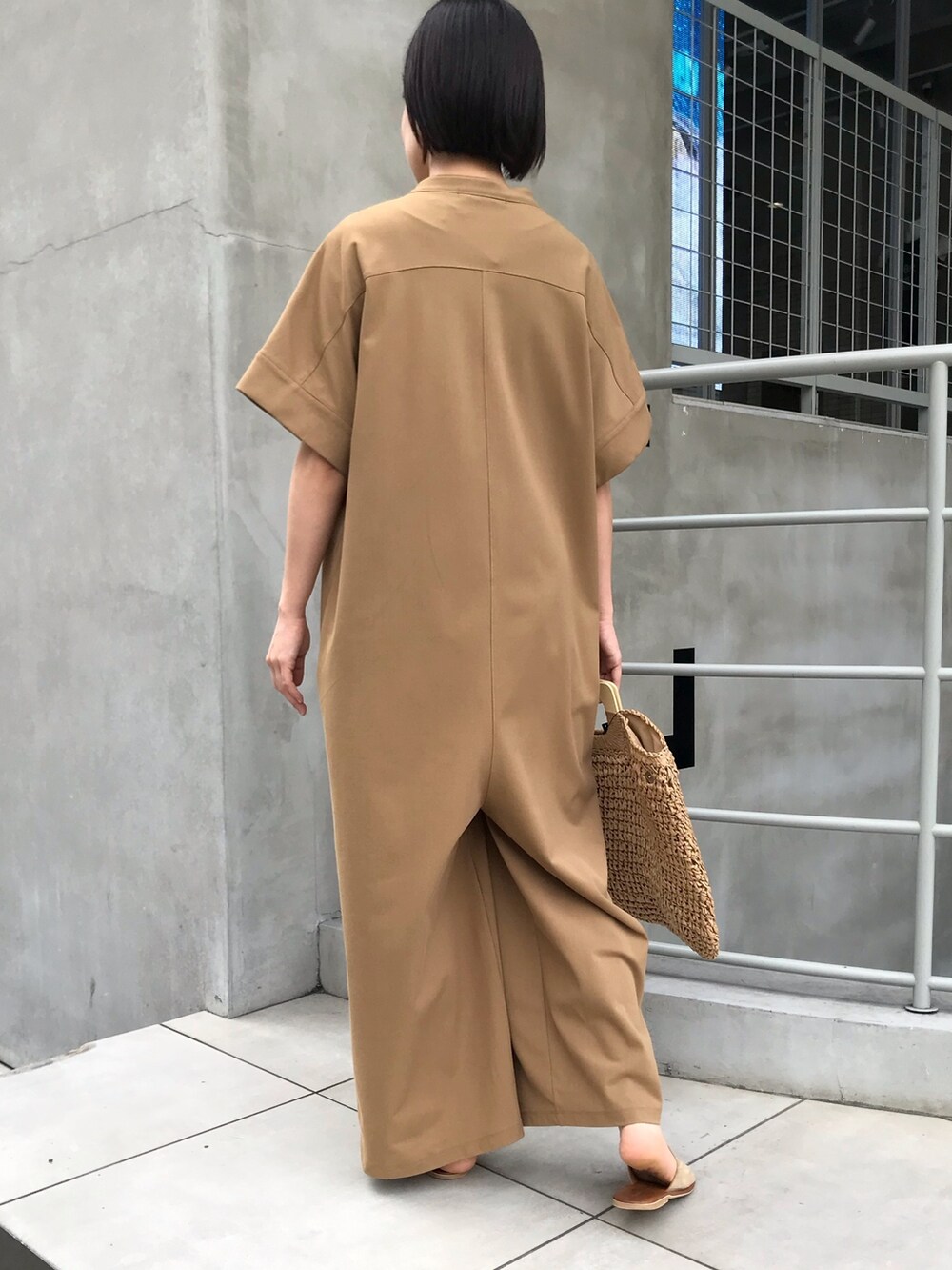 イエロー系のつなぎ/オールインワン、ベージュ系のかごバッグを着用したレディースの夏コーディネートの2枚目の写真