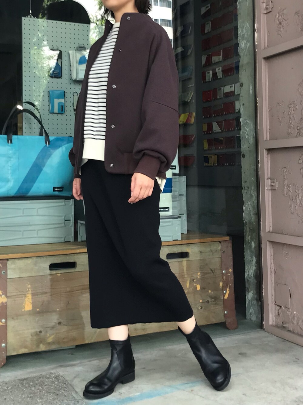 ブラック系のTシャツ/カットソー、ブラウン系のブルゾン、ブラック系のスカートを着用したレディースの秋コーディネートの2枚目の写真