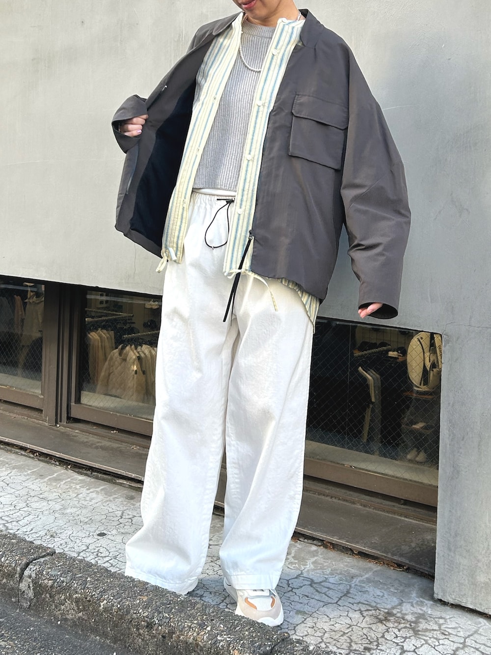 グレー系のブルゾン、グレー系のベスト、イエロー系のシャツ/ブラウスを着用したレディースの冬コーディネートの2枚目の写真