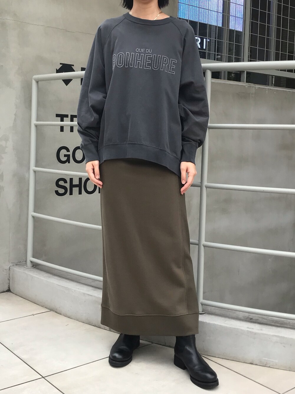 グレー系のTシャツ/カットソー、グリーン系のスカートを着用したレディースの夏コーディネートの2枚目の写真