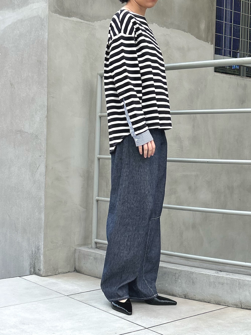 ブルー系のデニムパンツ、ブラック系のTシャツ/カットソーを着用したレディースの夏コーディネートの2枚目の写真