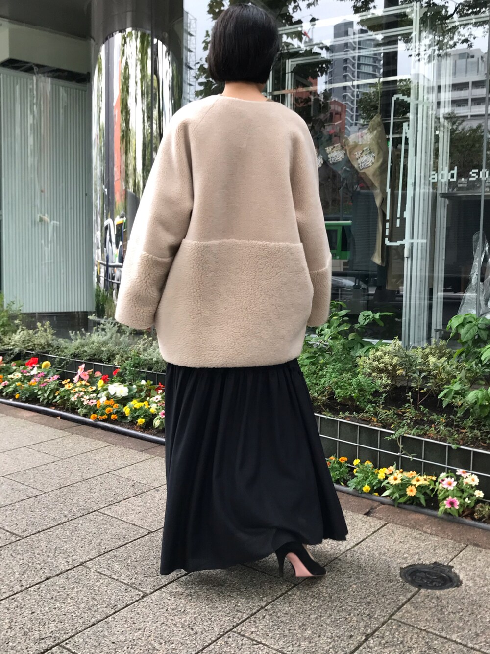 ブラック系のスカート、ベージュ系のムートンコートを着用したレディースの秋コーディネートの5枚目の写真