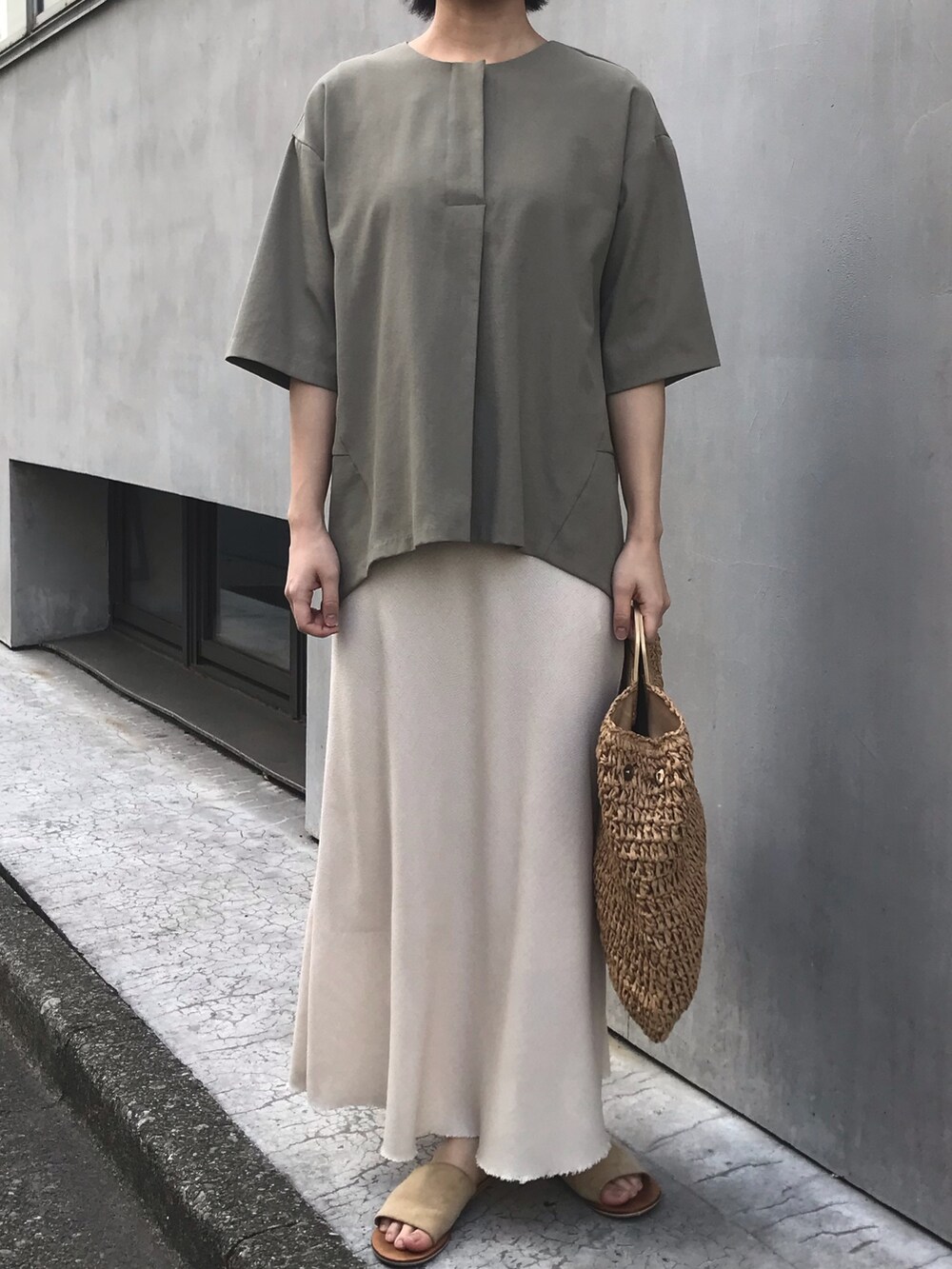 グリーン系のシャツ/ブラウス、ベージュ系のスカート、ベージュ系のかごバッグを着用したレディースの春コーディネートの2枚目の写真