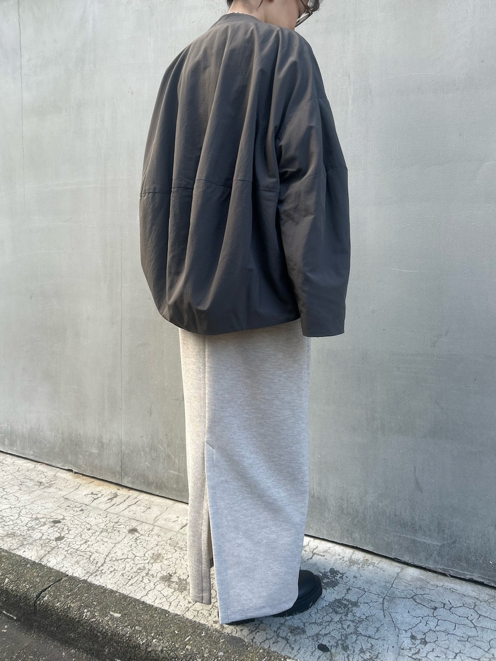 グレー系のブルゾン、ベージュ系のワンピース、ベージュ系のTシャツ/カットソーを着用したレディースの冬コーディネートの3枚目の写真