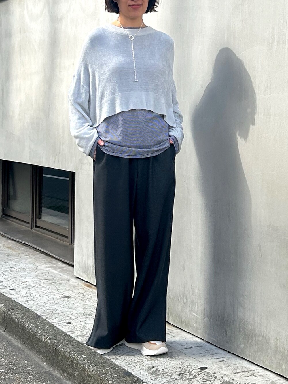 グレー系のその他パンツ、ブラック系のTシャツ/カットソー、グレー系のニット/セーターを着用したレディースの秋コーディネートの2枚目の写真