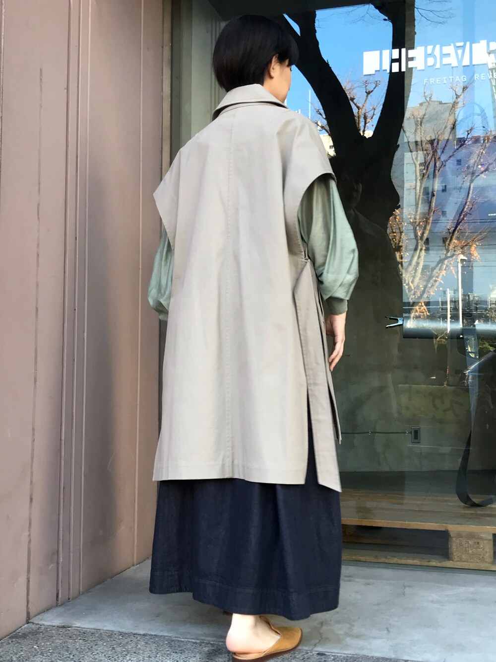 ベージュ系のその他アウター、グリーン系のシャツ/ブラウス、ブルー系のデニムスカートを着用したレディースの冬コーディネートの3枚目の写真