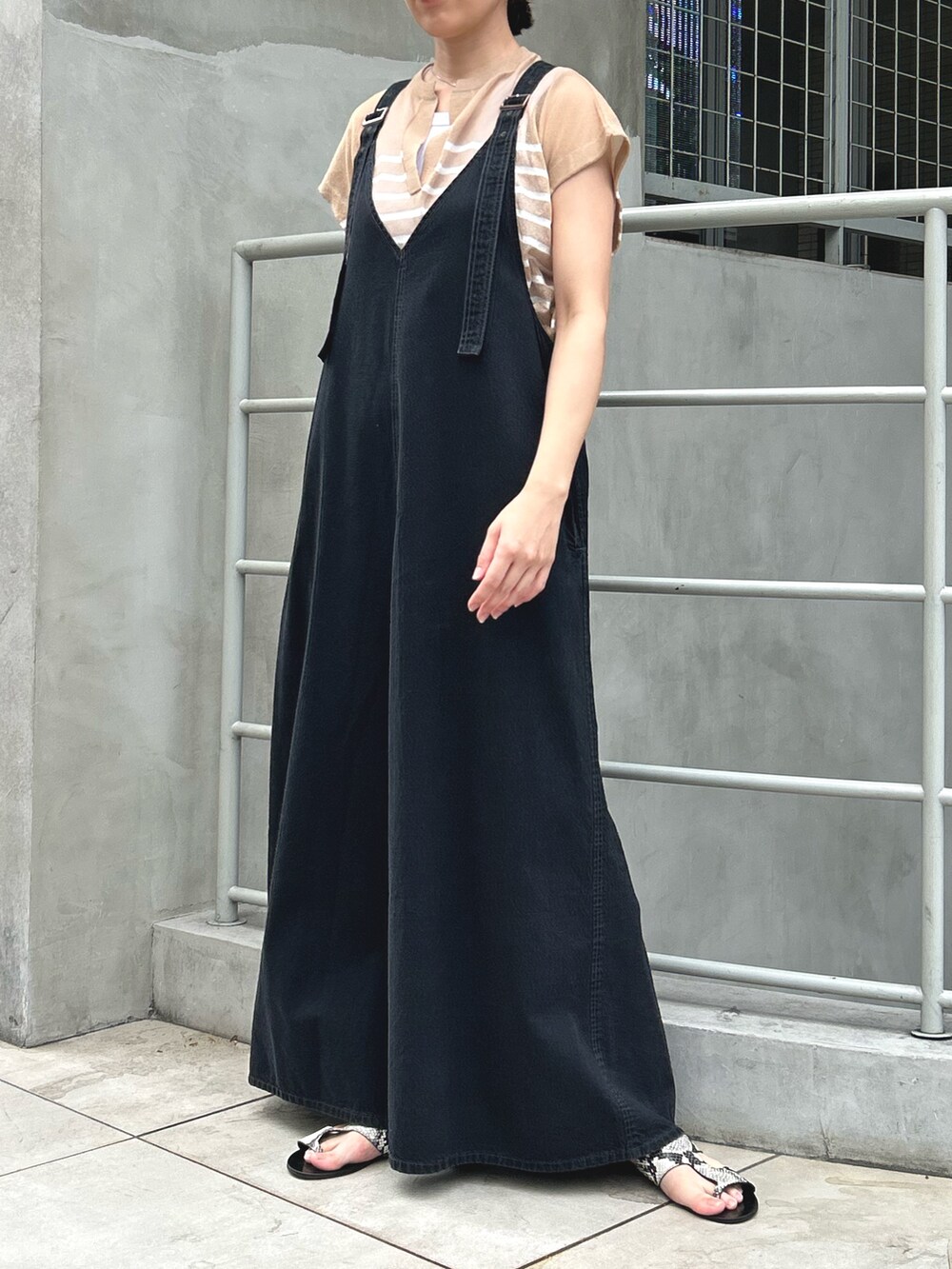 ブラック系のサロペット/オーバーオール、ベージュ系のニット/セーターを着用したレディースの夏コーディネートの2枚目の写真