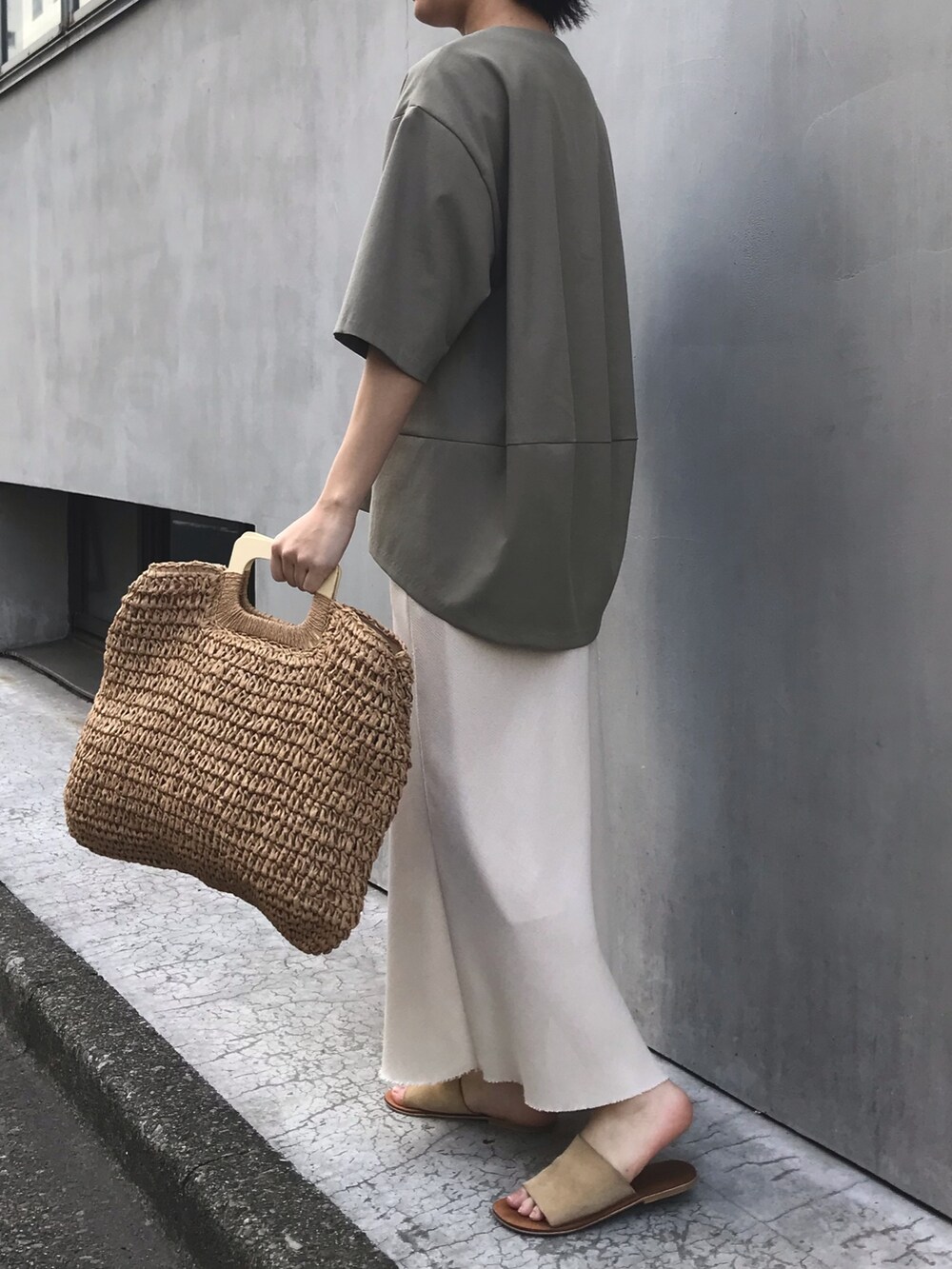 グリーン系のシャツ/ブラウス、ベージュ系のスカート、ベージュ系のかごバッグを着用したレディースの春コーディネートの3枚目の写真