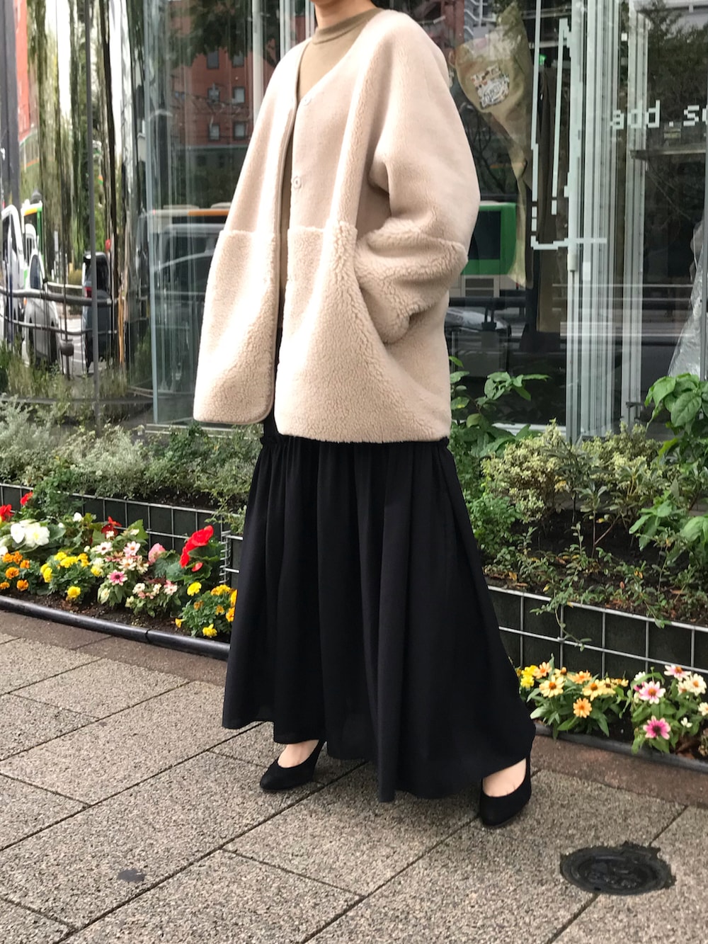 ブラック系のスカート、ベージュ系のムートンコートを着用したレディースの秋コーディネートの3枚目の写真