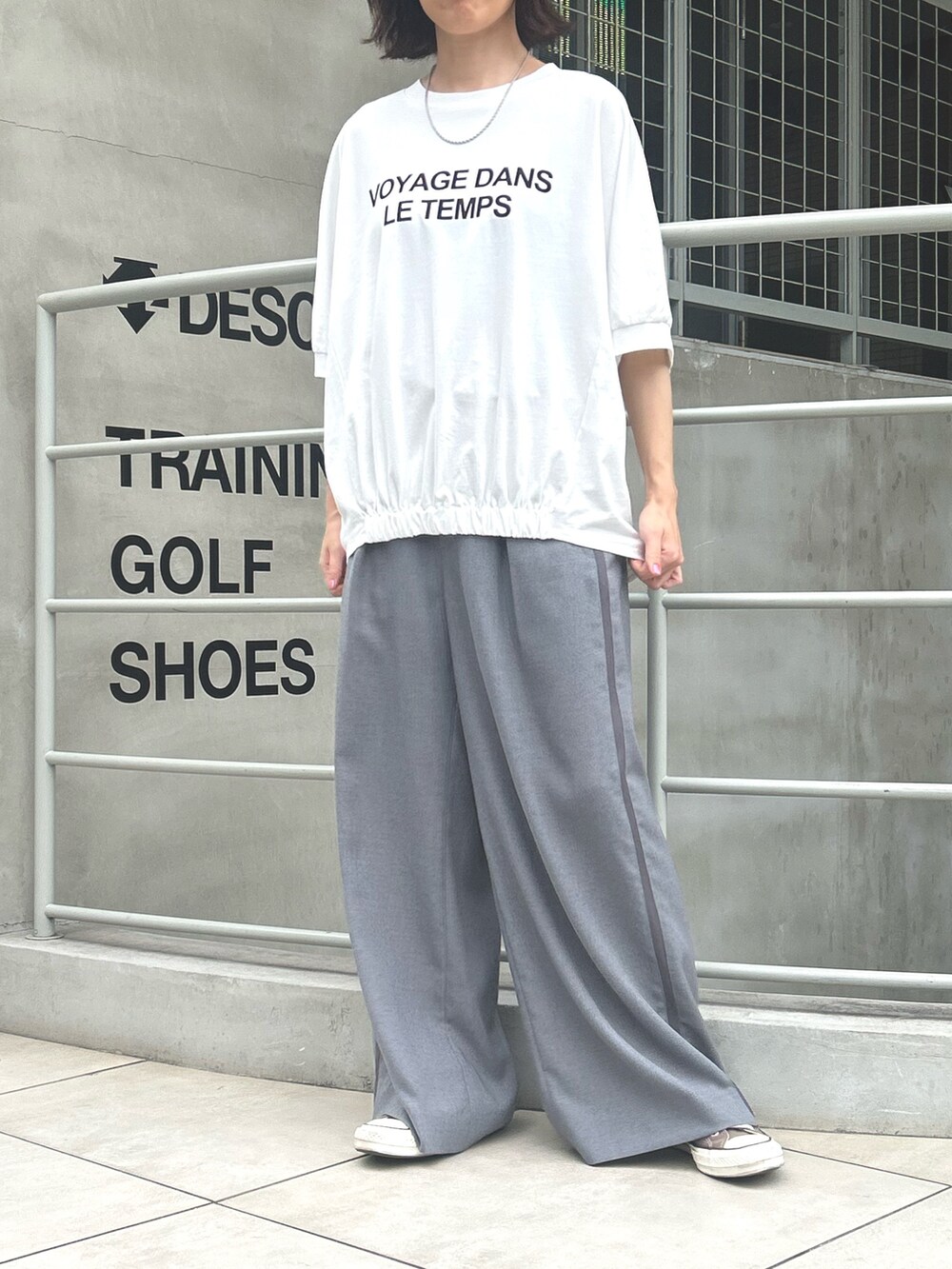 グレー系のスラックス、ホワイト系のTシャツ/カットソーを着用したレディースの秋コーディネートの3枚目の写真