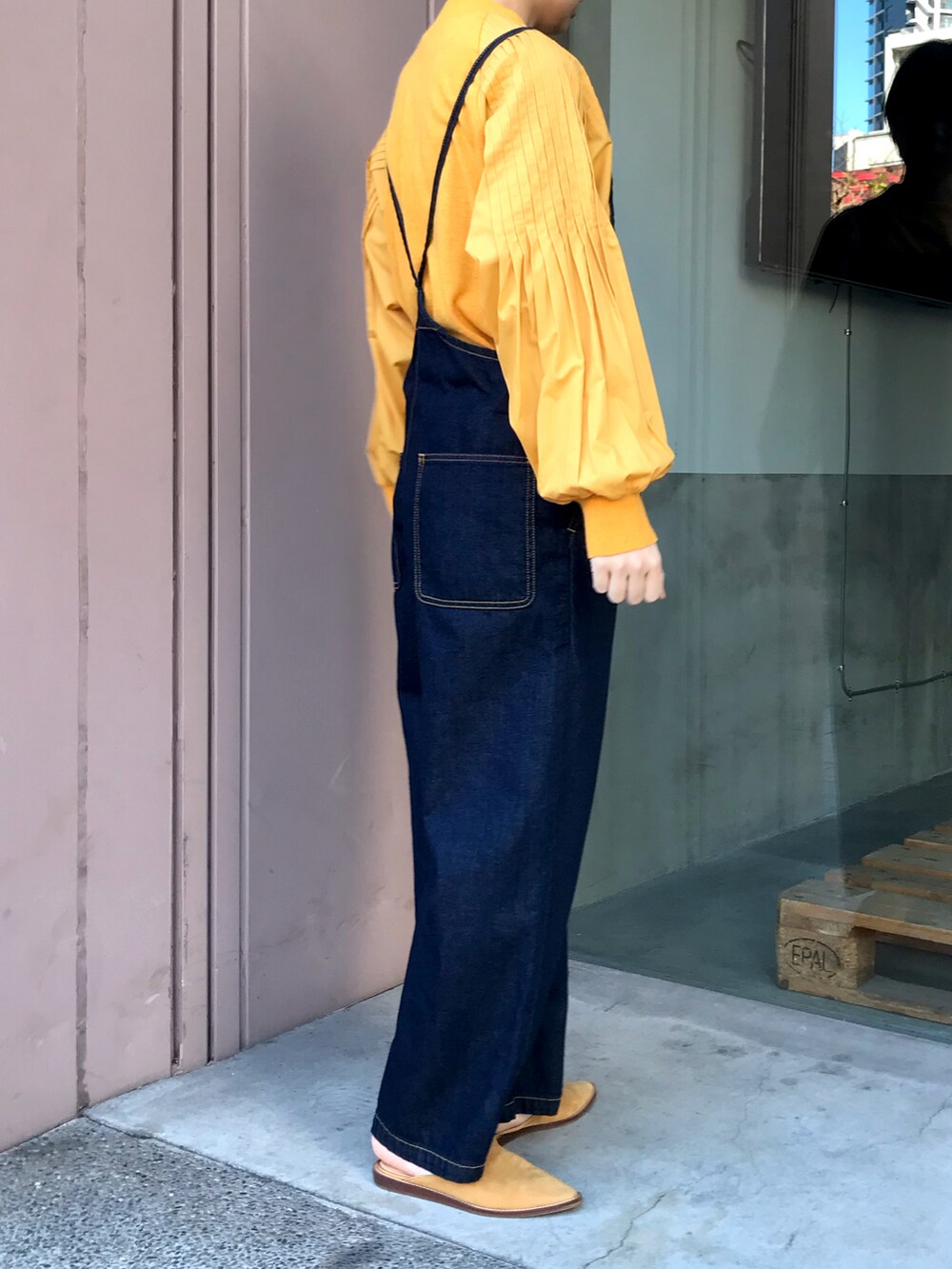 オレンジ系のニット/セーター、ブルー系のサロペット/オーバーオールを着用したレディースの冬コーディネートの3枚目の写真