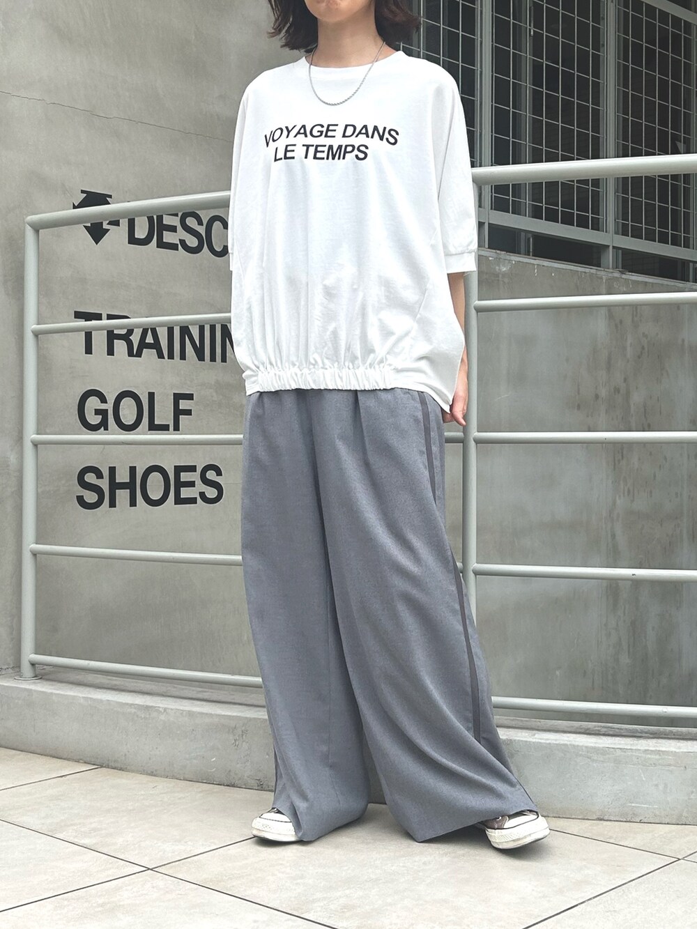 グレー系のスラックス、ホワイト系のTシャツ/カットソーを着用したレディースの秋コーディネートの4枚目の写真