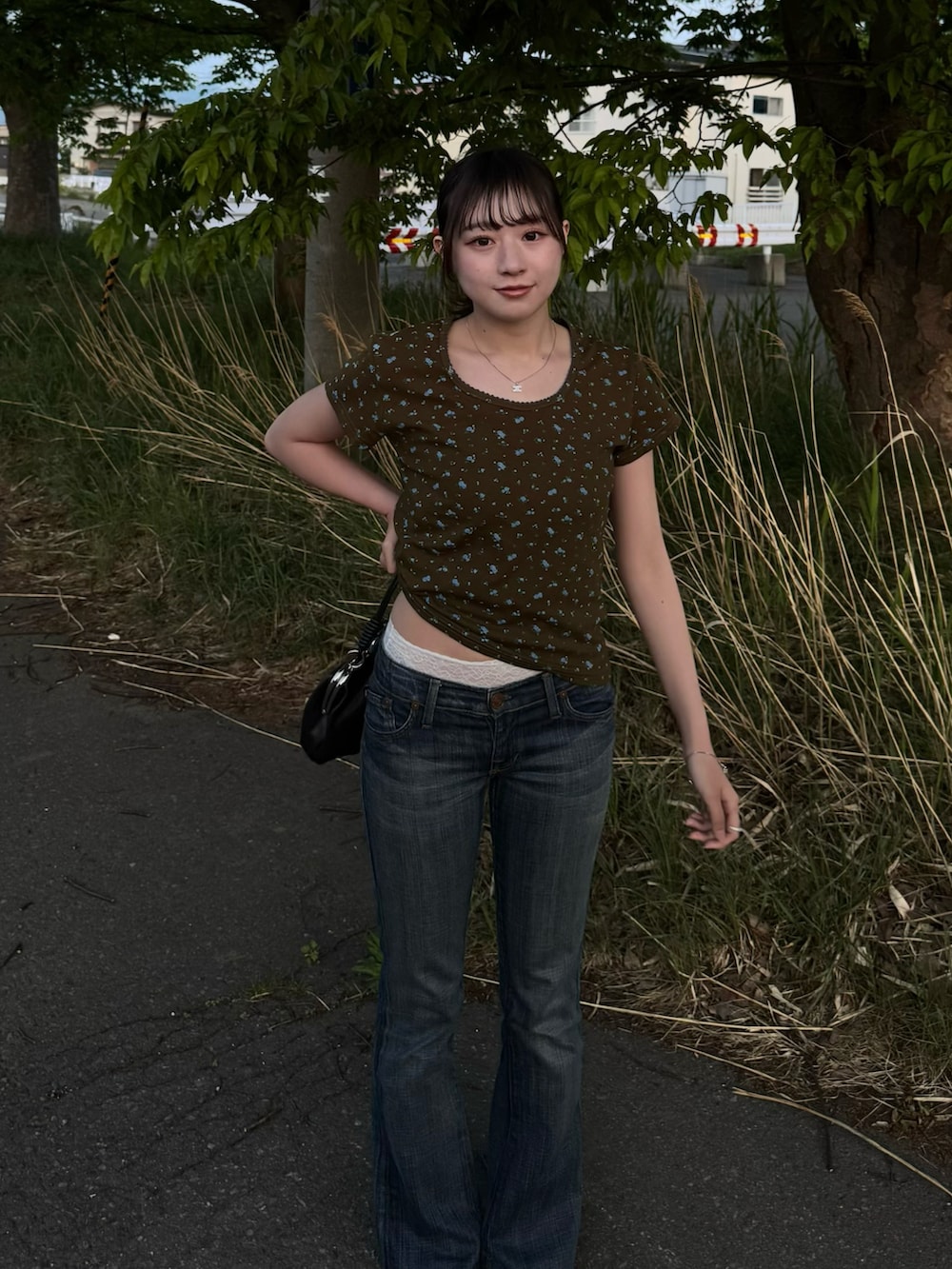 ブラウン系のTシャツ/カットソー、ブラック系のショルダーバッグ、ブラック系のスニーカーを着用したレディースの春コーディネートの2枚目の写真