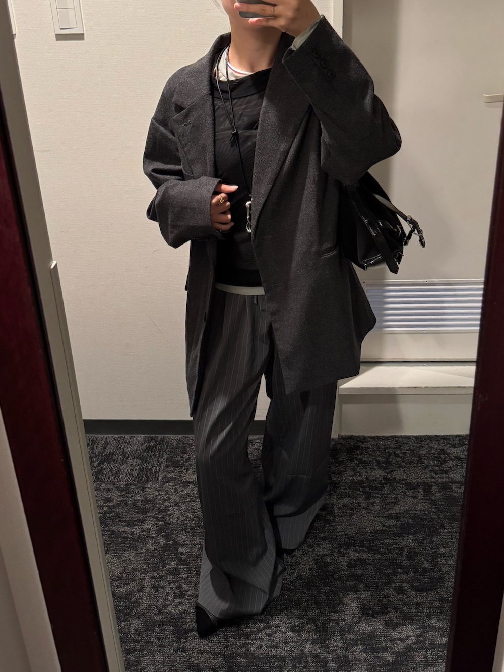 ブラック系のTシャツ/カットソー、グレー系のテーラードジャケット、グレー系のスラックスを着用したレディースの秋コーディネートの3枚目の写真
