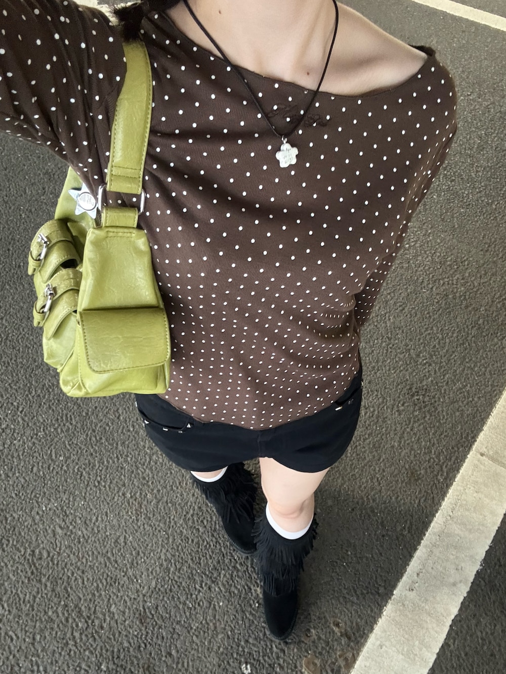 グリーン系のショルダーバッグ、ブラウン系のTシャツ/カットソー、ブラック系のパンツを着用したレディースの夏コーディネートの2枚目の写真
