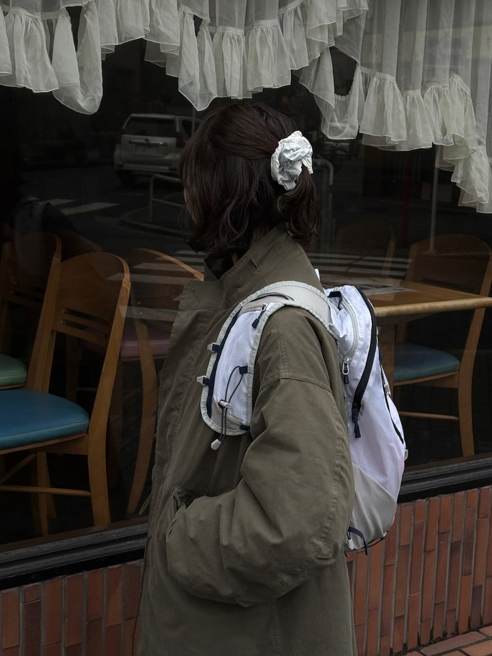 ホワイト系のバックパック/リュック、グリーン系のモッズコート、ホワイト系のスカートを着用したレディースの春コーディネートの2枚目の写真