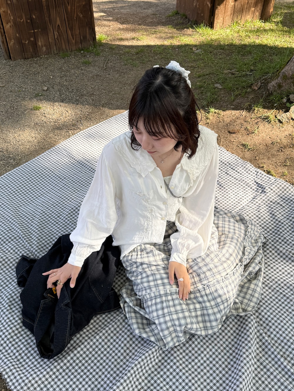 ブルー系のスカート、ホワイト系のパンプス、ピンク系のショルダーバッグを着用したレディースの春コーディネートの2枚目の写真