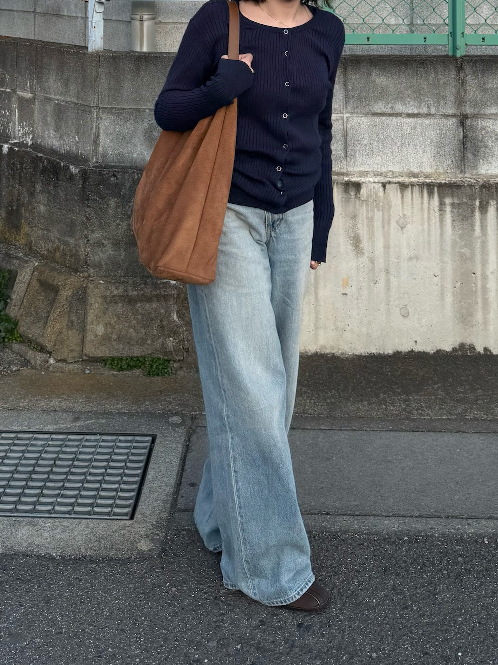 ブルー系のデニムパンツ、ブラウン系のスニーカー、ブラウン系のトートバッグを着用したレディースの春コーディネートの2枚目の写真